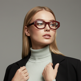 Woman wearing red glasses with a gray background